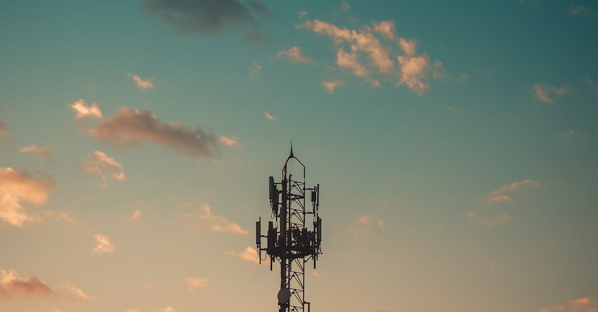 A communication tower silhouetted against a colorful sunset sky in Cruzeiro, Brazil.